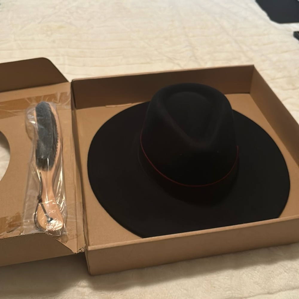 This hat is black felt with a red trim around the top of the hat